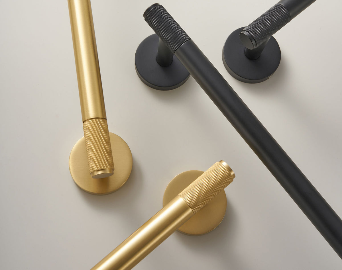 Brushed brass and dark bathroom accessory set with wall-mounted hooks and rails