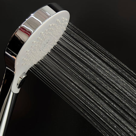 Close-up shower head showing strong water spray from multiple nozzles