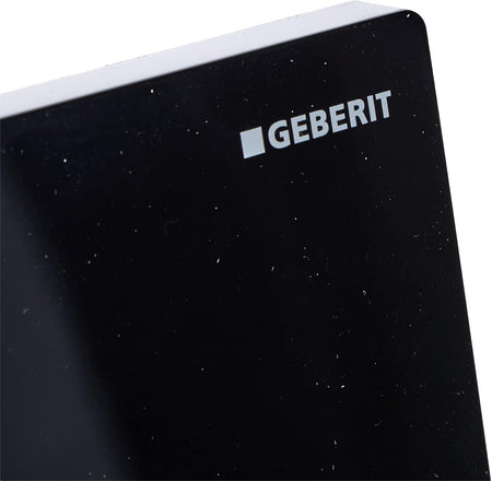 Geberit black flush plate front in glossy plastic with logo and speckled texture