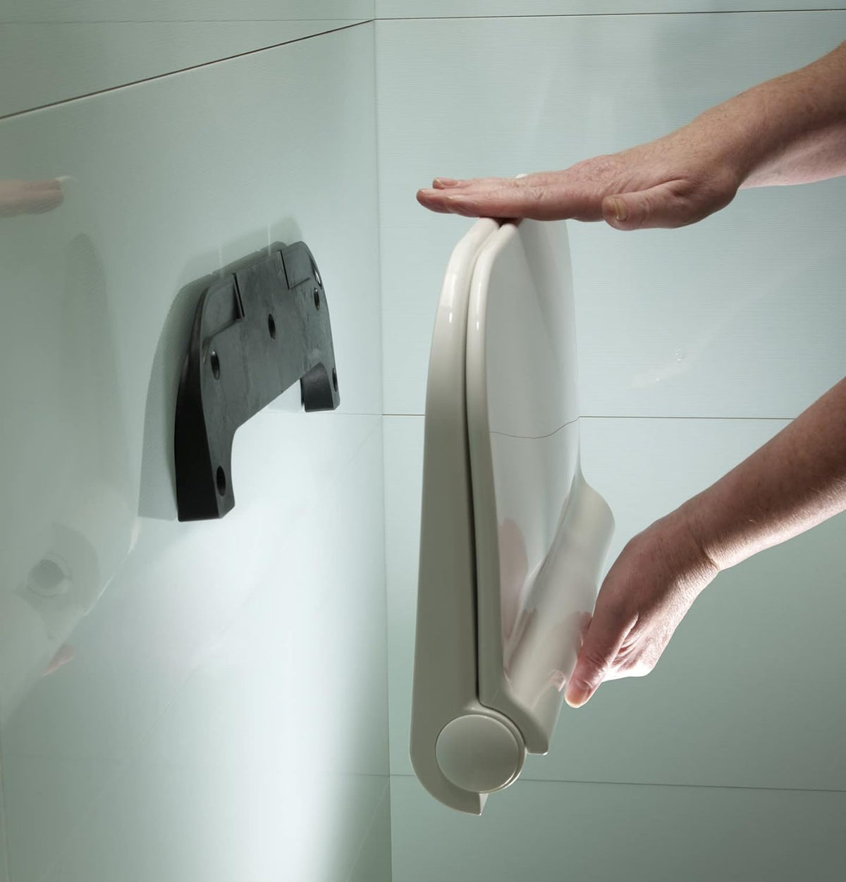 Wall-mounted shower seat folded down with contoured seat and rounded support