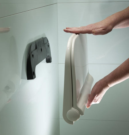 Wall-mounted shower seat folded down with contoured seat and rounded support