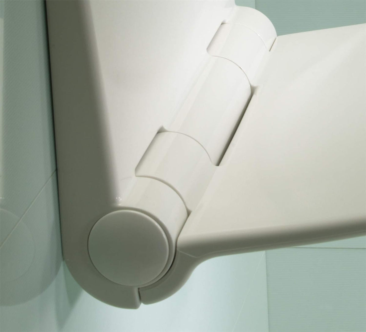 Wall-mounted shower seat hinge and backrest details with light-grey plastic
