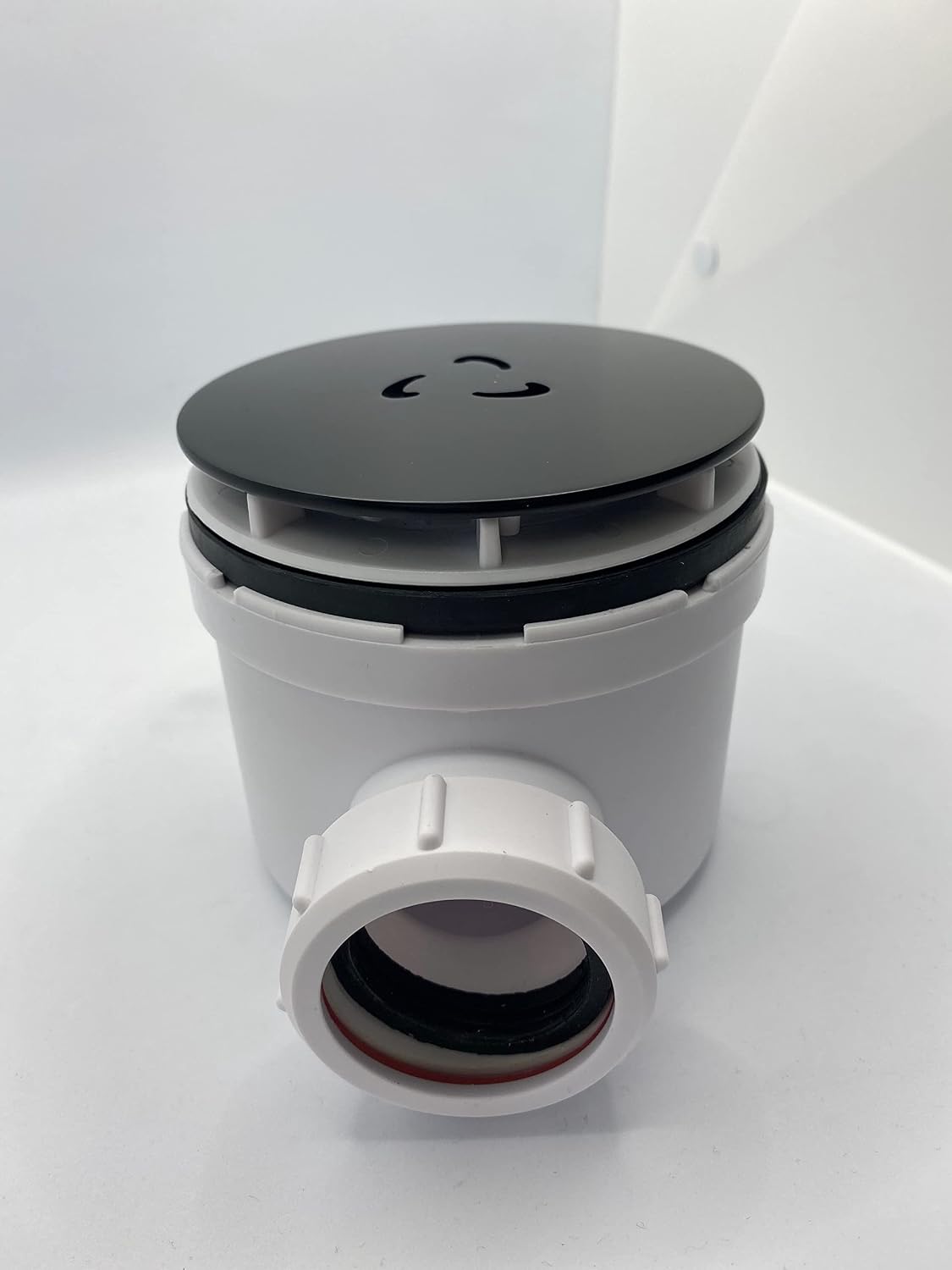 Round matt black waste cover lid on gray/white waste valve body