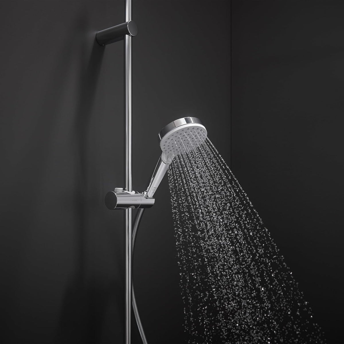Chrome hand shower head spraying water, on vertical slide bar