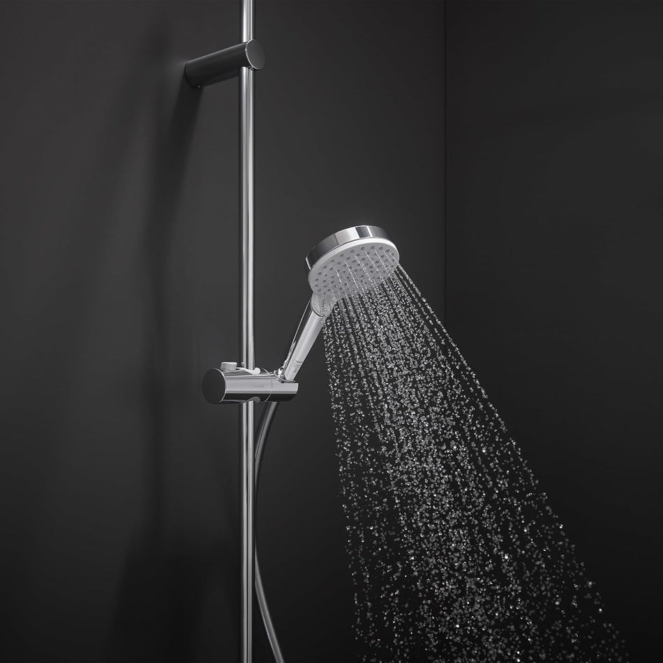 Chrome hand shower head spraying water, on vertical slide bar