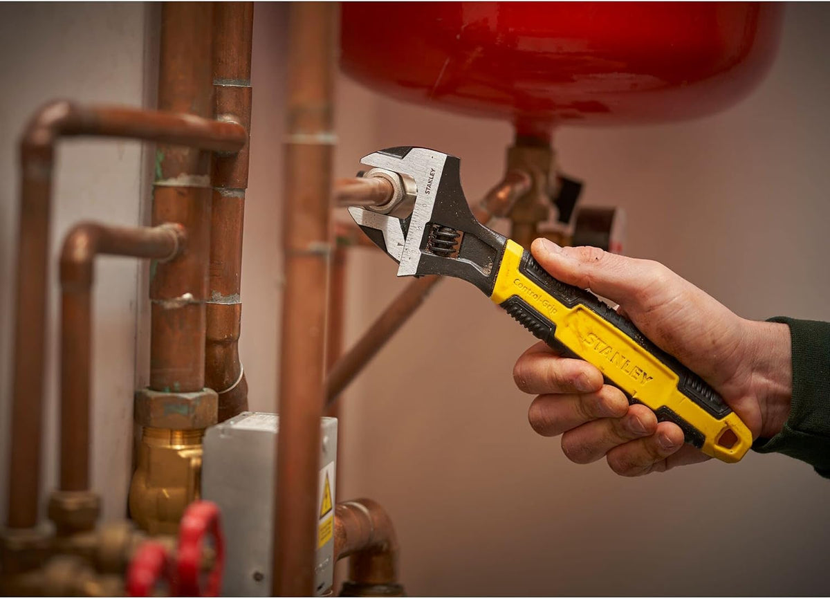 Adjustable wrench held in hand, MaxSteel 150mm with yellow grip and black jaws