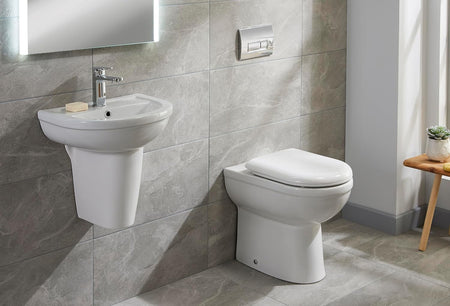 Chrome dual flush toilet plate mounted on tiled wall above a white toilet