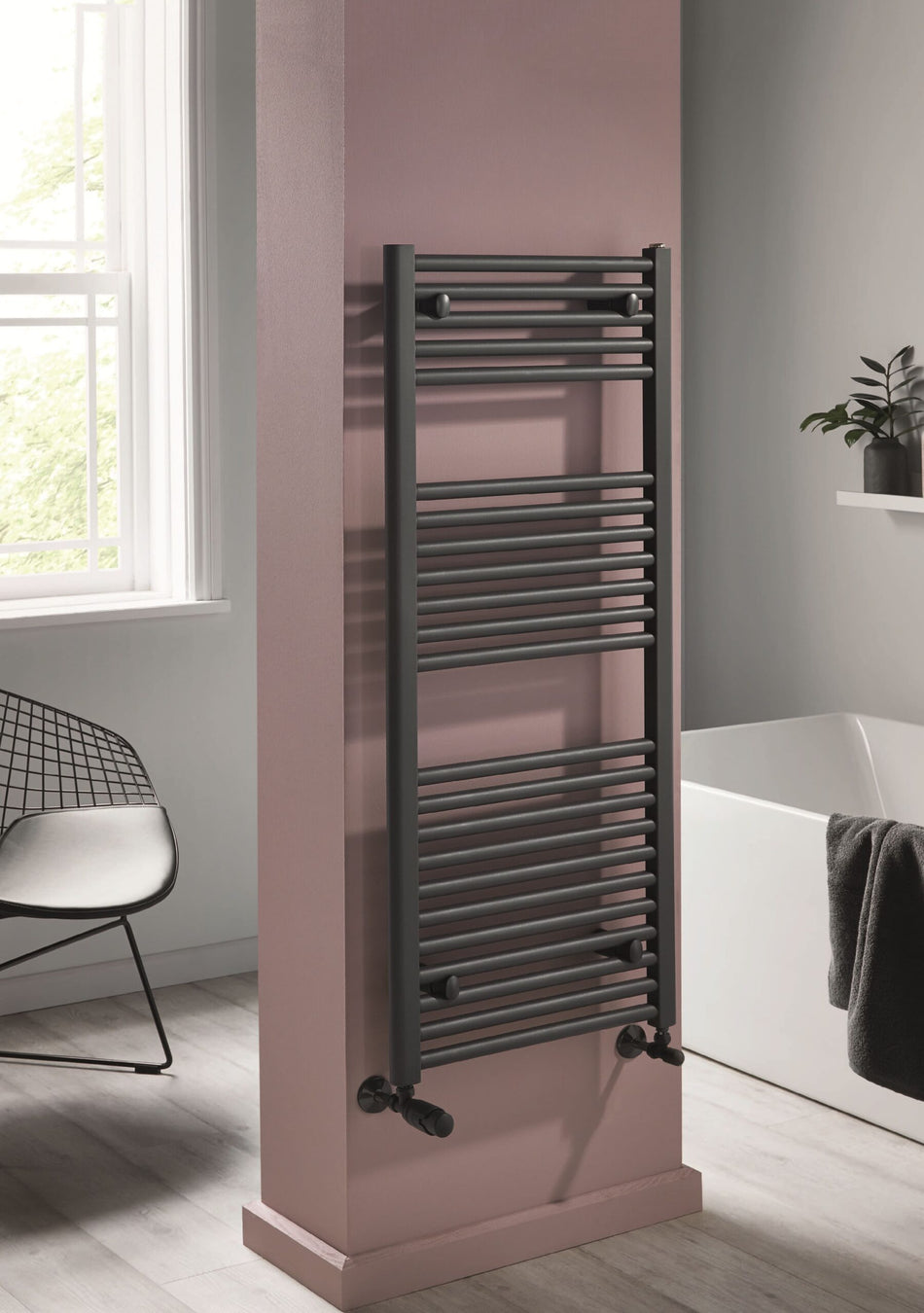 Modern black column radiator with horizontal bars and thermostatic valve knobs