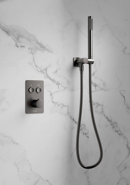 Gunmetal hand shower set on wall with handheld shower head and flexible hose