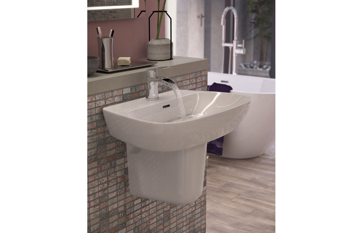 White basin with semi pedestal and faucet, front three-quarter view