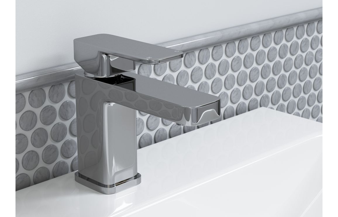 Chrome basin mixer tap installed on countertop with single lever handle