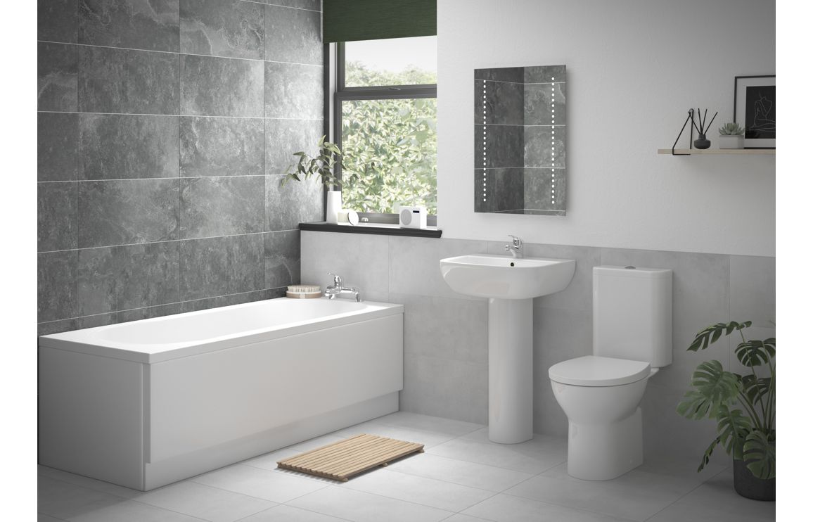 White bathroom fixture set with bathtub, wall sink, pedestal toilet, and chrome taps