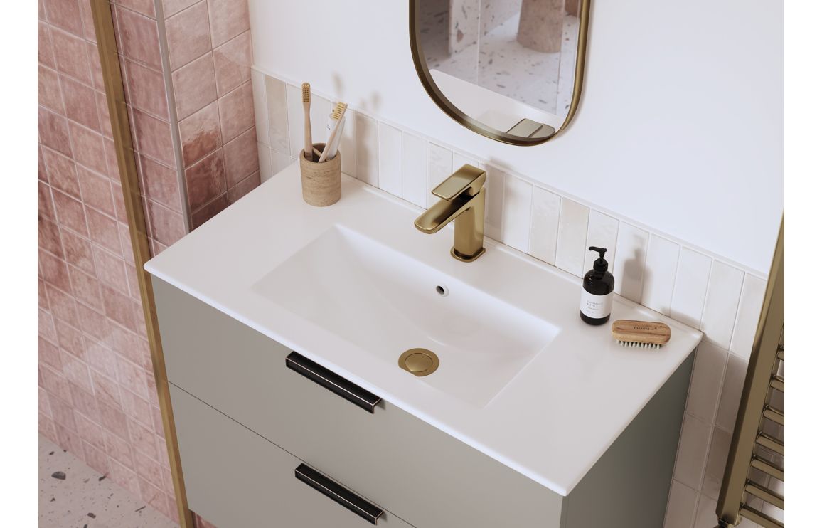Brushed bronze basin mixer tap on white sink with soap dispenser