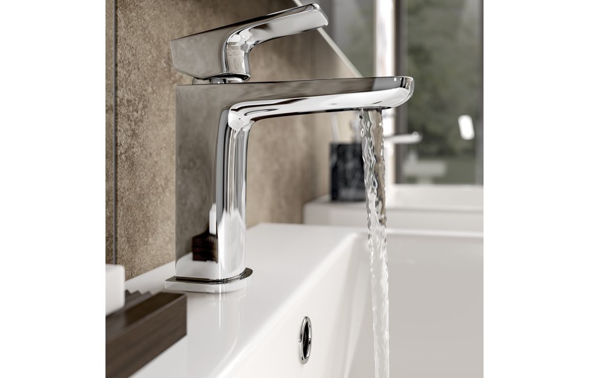 Chrome faucet spout over sink with curved body and reflective finish