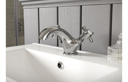 Chrome floor mixer tap with single lever and handheld shower on bathtub