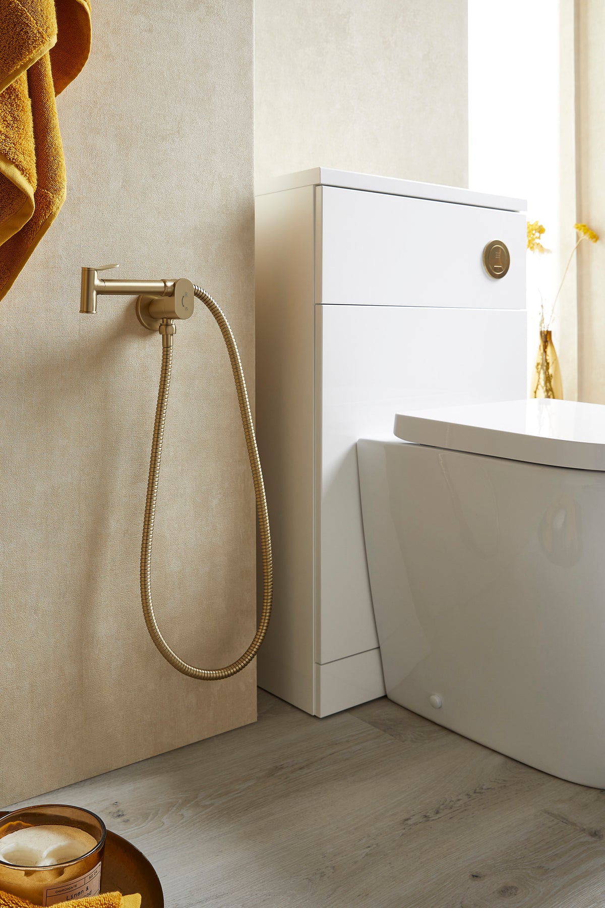 Brushed brass bidet douche kit with wall faucet, flexible hose, and spray head