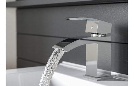 Chrome basin mixer faucet with square spout and flowing water stream