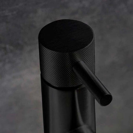 Matt black basin mixer tap close-up with knurled cylindrical handle