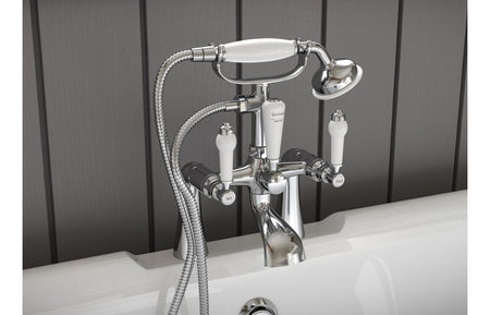 Chrome basin mixer tap with flexible hose and dual control levers on sink