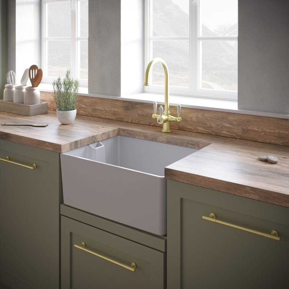 Undermount white kitchen sink with round drain strainer in a cabinet