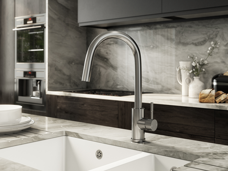 Brushed steel kitchen mixer tap with pull-out sprayer over sink
