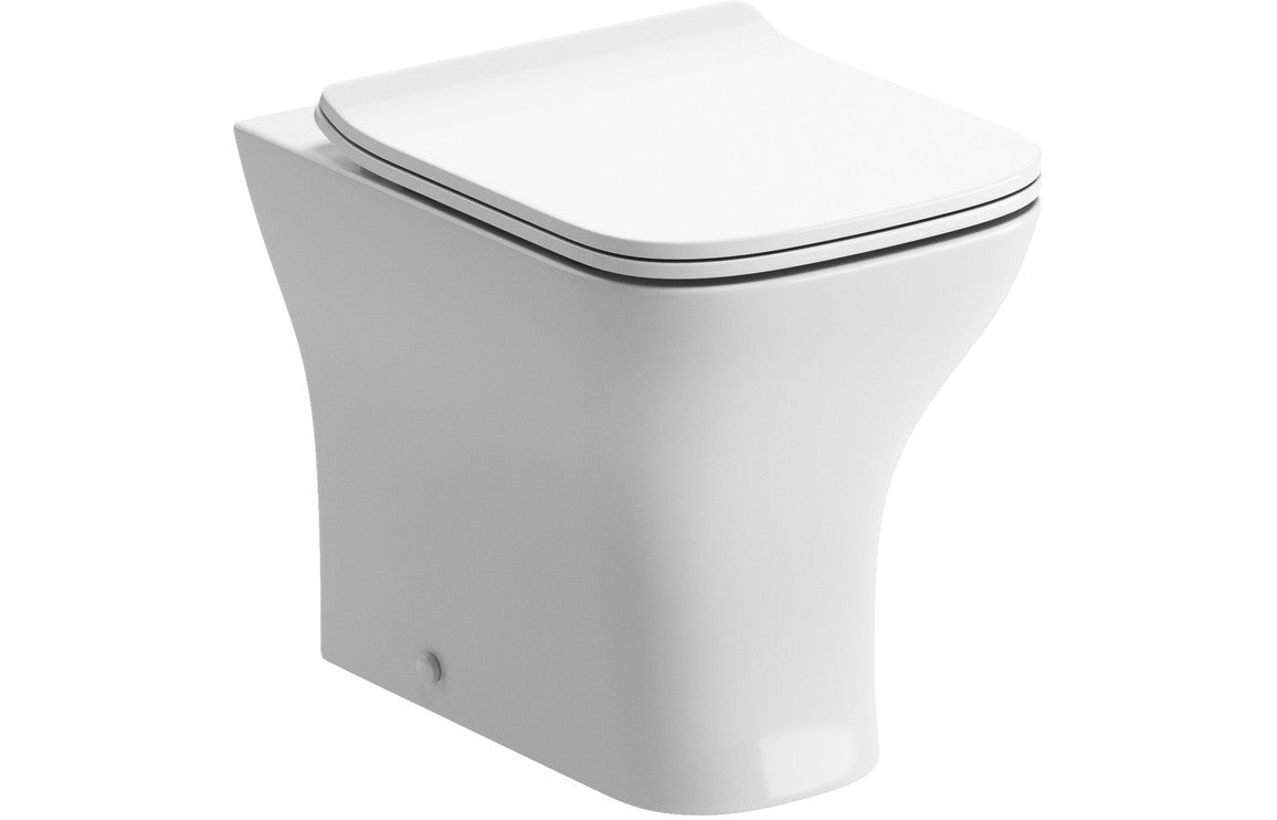 Rimless back-to-wall toilet pan with white closed seat and soft-close hinges