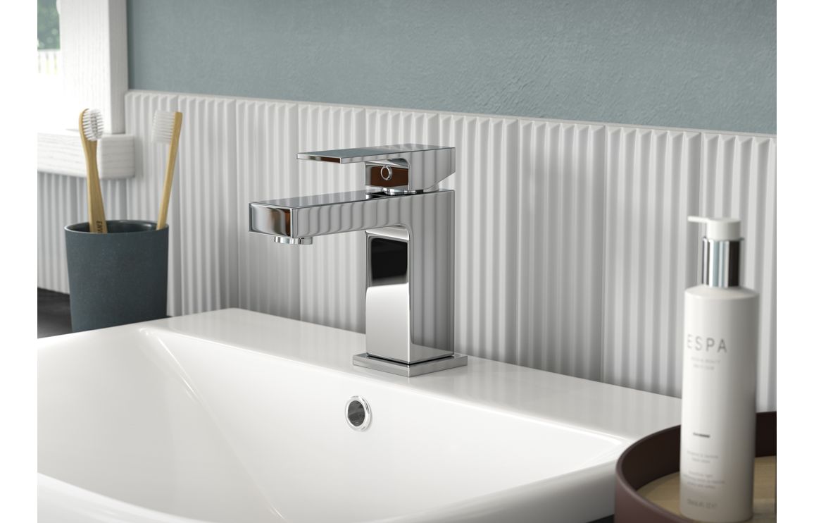 Chrome single-handle bath filler faucet on countertop above bathtub